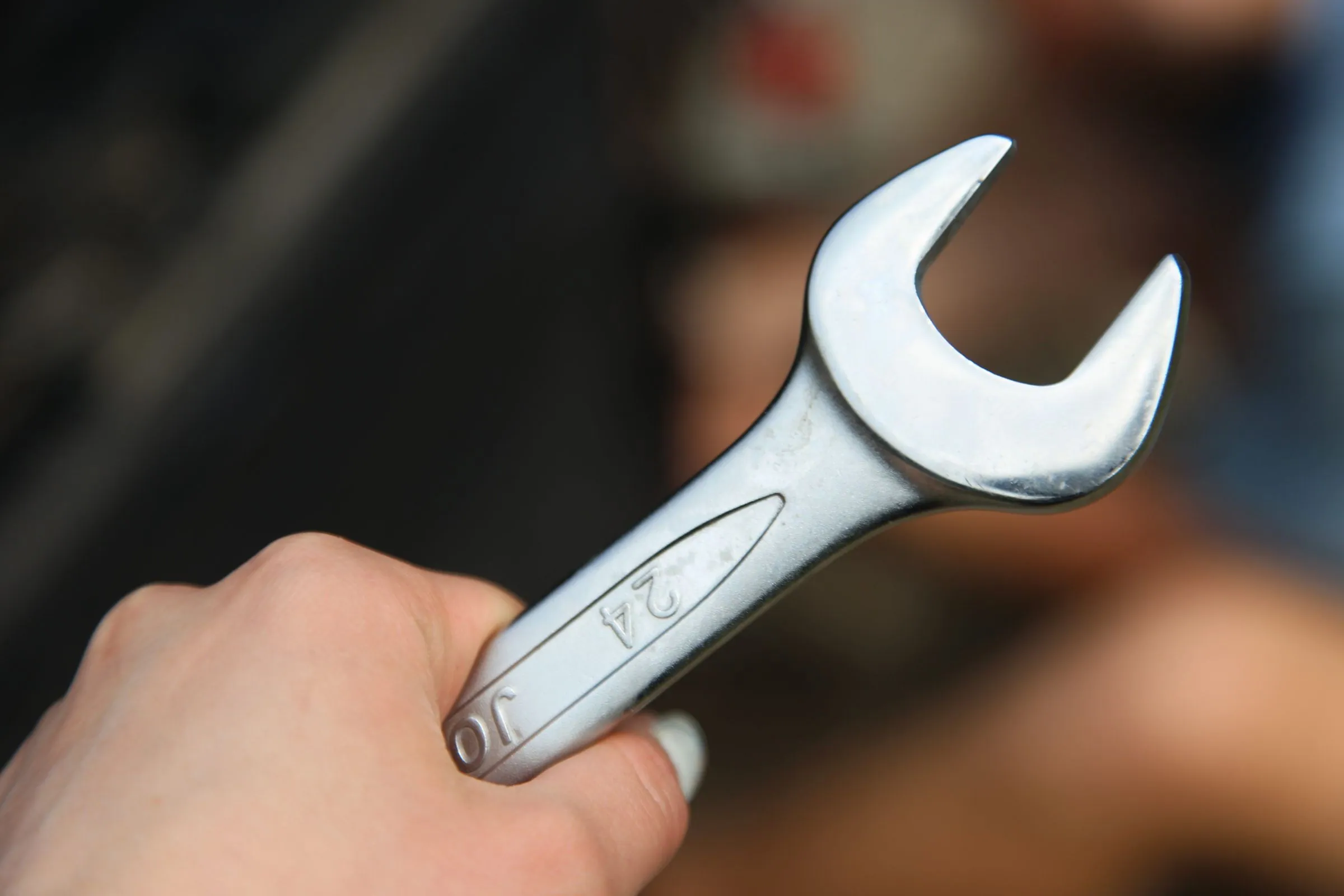 Hand holding a metal wrench